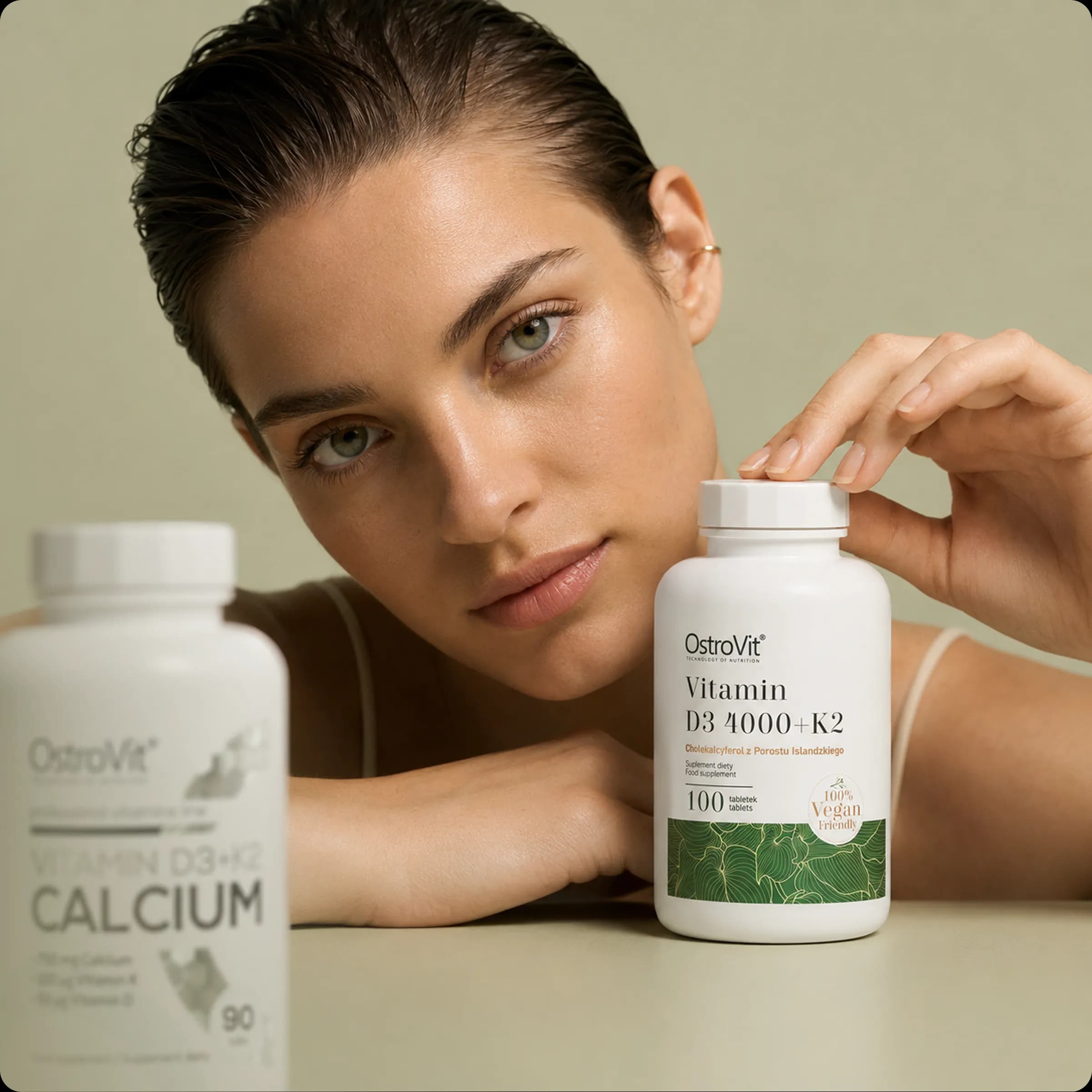 Woman holding a bottle of myGP vitamin D3+K2 alongside a calcium supplement