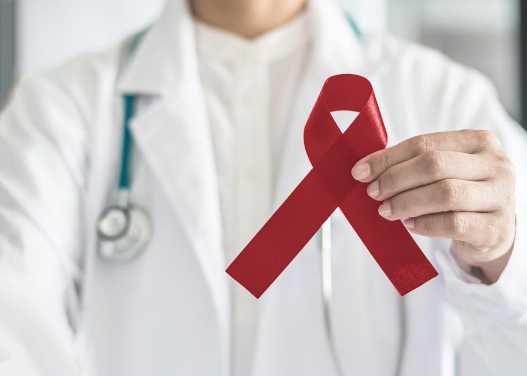 Doctor holding a red sickle cell ribbon